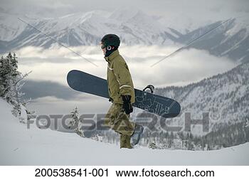 Stock Photography - canada, alberta, 
young woman carrying 
snowboard, side 
view. fotosearch 
- search stock 
photos, pictures, 
images, and photo 
clipart