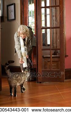 Stock Photography - cat greeting mature 
woman in entryway 
of house. fotosearch 
- search stock 
photos, pictures, 
images, and photo 
clipart