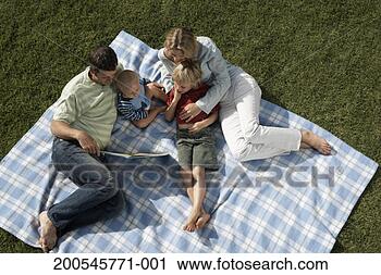 Stock Photography - family with two 
children (14 months 
- 6) with book 
on picnic blanket. 
fotosearch - search 
stock photos, 
pictures, images, 
and photo clipart