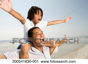 Stock Photography - father carrying 
son (6-8) on shoulders 
on beach, arms 
outstretched. 
fotosearch - search 
stock photos, 
pictures, images, 
and photo clipart