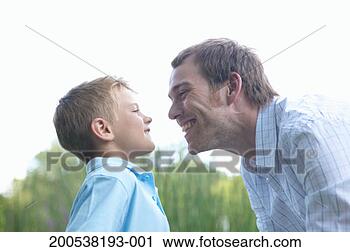 Stock Photography - father and son 
(6-8) smiling 
at each other 
in park, close-up. 
fotosearch - search 
stock photos, 
pictures, images, 
and photo clipart