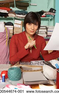 Stock Photography - female fashion 
designer holding 
piece of paper 
and pencil, portrait. 
fotosearch - search 
stock photos, 
pictures, images, 
and photo clipart