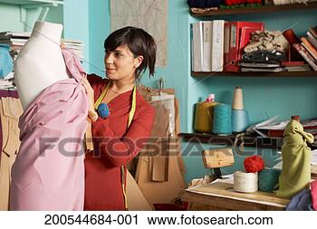 Stock Photography - female fashion 
designer working 
on dress on mannequin. 
fotosearch - search 
stock photos, 
pictures, images, 
and photo clipart