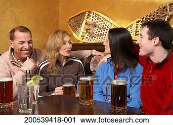 Stock Photography - four adults drinking 
beer and talking 
in pub. fotosearch 
- search stock 
photos, pictures, 
images, and photo 
clipart