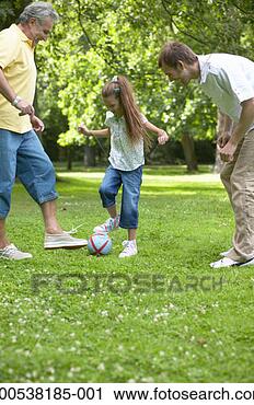 Stock Photography - girl (7-9) playing 
football in park 
with father and 
grandfather. fotosearch 
- search stock 
photos, pictures, 
images, and photo 
clipart