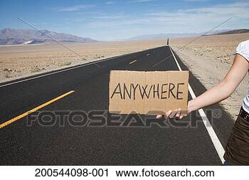 Stock Photography - hitchhiker with 
sign to anywhere 
on empty road 
in desert,  close-up. 
fotosearch - search 
stock photos, 
pictures, images, 
and photo clipart