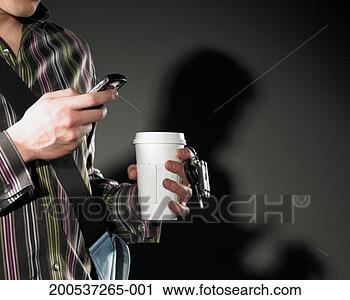 Stock Photography - man checking mobile 
phone while other 
hand holding cup 
and keys. fotosearch 
- search stock 
photos, pictures, 
images, and photo 
clipart