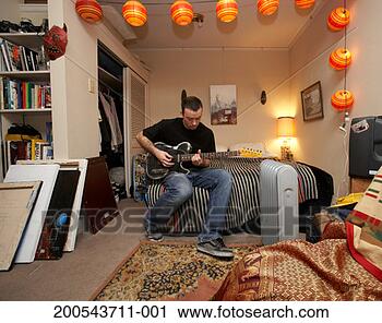 Stock Photography - man playing electric 
guitar on bed 
in art studio. 
fotosearch - search 
stock photos, 
pictures, images, 
and photo clipart
