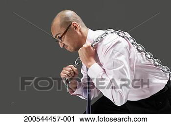 Stock Photography - man struggling 
to pull chain, 
studio shot. fotosearch 
- search stock 
photos, pictures, 
images, and photo 
clipart
