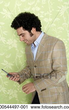 Stock Photography - man text messaging 
using mobile phone, 
against wallpaper 
background. fotosearch 
- search stock 
photos, pictures, 
images, and photo 
clipart
