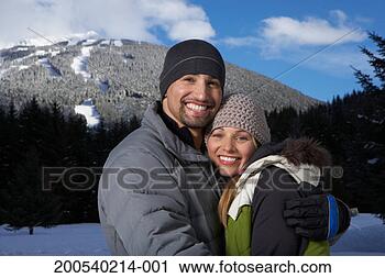 Stock Photography - man and woman 
embracing beside 
snow-covered mountain, 
portrait. fotosearch 
- search stock 
photos, pictures, 
images, and photo 
clipart