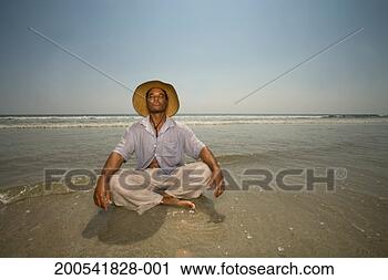 Stock Photography - mature man with 
sun hat sitting 
in surf, eyes 
closed. fotosearch 
- search stock 
photos, pictures, 
images, and photo 
clipart