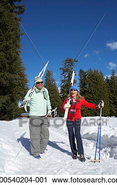 Stock Photography - mature man and 
woman carrying 
cross-country 
skis, laughing. 
fotosearch - search 
stock photos, 
pictures, images, 
and photo clipart