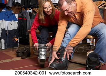 Stock Photography - mature man and 
woman trying on 
ski boots in sports 
shop. fotosearch 
- search stock 
photos, pictures, 
images, and photo 
clipart