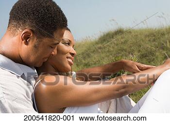 Stock Photography - mature man and 
young woman embracing 
on beach, side 
view. fotosearch 
- search stock 
photos, pictures, 
images, and photo 
clipart