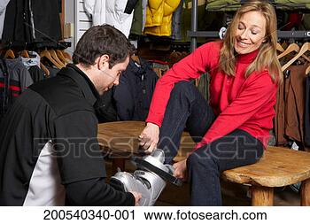 Stock Photography - salesman helping 
mature woman try 
on ski boots in 
sports shop. fotosearch 
- search stock 
photos, pictures, 
images, and photo 
clipart