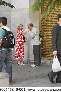 Stock Photography - senior man holding 
roses kissing 
mature woman's 
hand in street. 
fotosearch - search 
stock photos, 
pictures, images, 
and photo clipart