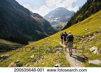 Stock Photography - switzerland, kandersteg, 
three hikers on 
footpath, rear 
view. fotosearch 
- search stock 
photos, pictures, 
images, and photo 
clipart