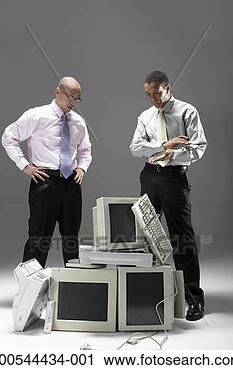 Stock Photography - two businessmen 
standing over 
pile of old technology, 
studio shot. fotosearch 
- search stock 
photos, pictures, 
images, and photo 
clipart