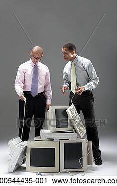 Stock Photography - two businessmen 
standing over 
pile of old technology, 
studio shot. fotosearch 
- search stock 
photos, pictures, 
images, and photo 
clipart