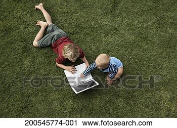 Stock Photography - two children (14 
months -6) playing 
on grass with 
laptop. fotosearch 
- search stock 
photos, pictures, 
images, and photo 
clipart