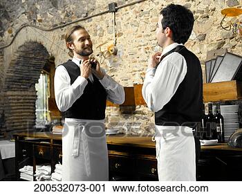 Stock Photography - two waiters tying 
bow ties in restaurant, 
smiling. fotosearch 
- search stock 
photos, pictures, 
images, and photo 
clipart