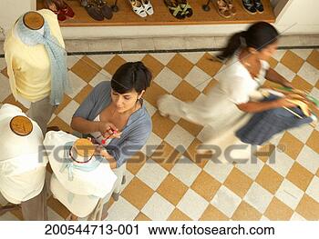 Stock Photography - two women in shop, 
one dressing mannequin, 
one carrying clothes. 
fotosearch - search 
stock photos, 
pictures, images, 
and photo clipart