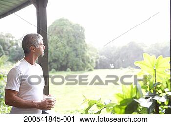 Stock Photography - usa, hawaii, big 
island, mature 
man holding coffee 
cup on porch. 
fotosearch - search 
stock photos, 
pictures, images, 
and photo clipart
