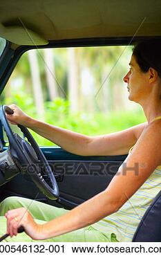 Stock Photography - woman driving 
vehicle in forest, 
side view. fotosearch 
- search stock 
photos, pictures, 
images, and photo 
clipart