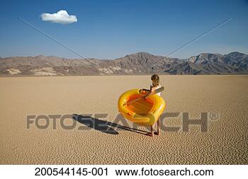 Stock Photography - woman with inflatable 
dinghy in desert, 
rear view. fotosearch 
- search stock 
photos, pictures, 
images, and photo 
clipart