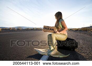 Stock Photography - woman in mermaid 
costume by empty 
road with sign 
'to ocean'. fotosearch 
- search stock 
photos, pictures, 
images, and photo 
clipart