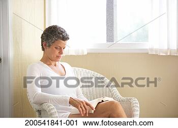 Stock Photography - woman sitting 
on wicker armchair, 
reading book. 
fotosearch - search 
stock photos, 
pictures, images, 
and photo clipart