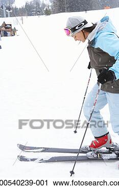 Stock Photography - woman with skis 
at base of mountain, 
side view. fotosearch 
- search stock 
photos, pictures, 
images, and photo 
clipart
