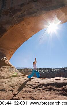 Stock Photography - woman in yoga 
position under 
rocks, side view. 
fotosearch - search 
stock photos, 
pictures, images, 
and photo clipart