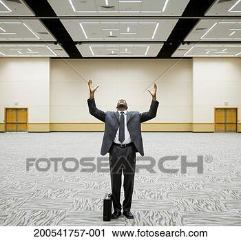 Stock Photography - young businessman 
standing in empty 
auditorium, arms 
raised, head back. 
fotosearch - search 
stock photos, 
pictures, images, 
and photo clipart