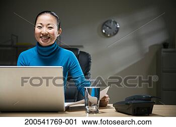 Stock Photography - young businesswoman 
working late, 
smiling, portrait. 
fotosearch - search 
stock photos, 
pictures, images, 
and photo clipart