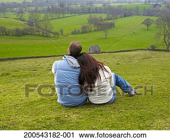 Stock Photography - young couple sitting 
on hill looking 
at view, rear 
view. fotosearch 
- search stock 
photos, pictures, 
images, and photo 
clipart