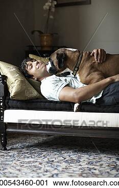 Stock Photography - young man and 
dog lying on sofa, 
dog licking man's 
face. fotosearch 
- search stock 
photos, pictures, 
images, and photo 
clipart