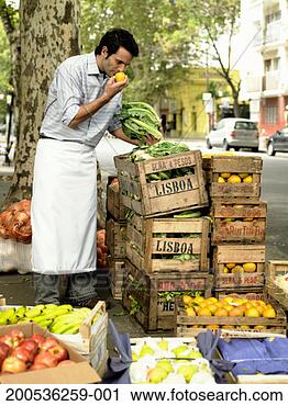 Stock Photography - young man eating 
fruit from street 
market stall. 
fotosearch - search 
stock photos, 
pictures, images, 
and photo clipart