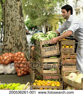 Stock Photography - young man preparing 
market stall on 
street. fotosearch 
- search stock 
photos, pictures, 
images, and photo 
clipart
