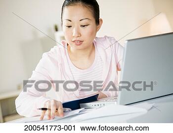 Stock Photography - young woman with 
bills and checkbook 
sitting at laptop. 
fotosearch - search 
stock photos, 
pictures, images, 
and photo clipart
