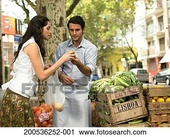 Stock Photography - young woman buying 
fruit from market 
trader. fotosearch 
- search stock 
photos, pictures, 
images, and photo 
clipart