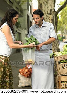 Stock Photography - young woman buying 
vegetables from 
market trader. 
fotosearch - search 
stock photos, 
pictures, images, 
and photo clipart