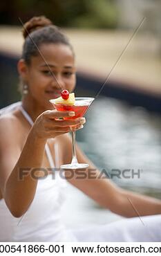 Stock Photography - young woman with 
cocktail beside 
pool, side view 
(focus on cocktail). 
fotosearch - search 
stock photos, 
pictures, images, 
and photo clipart