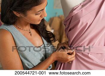 Stock Photography - young woman pinning 
dress on mannequin, 
close-up. fotosearch 
- search stock 
photos, pictures, 
images, and photo 
clipart