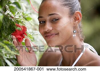 Stock Photography - young woman smelling 
flower, smiling, 
portrait. fotosearch 
- search stock 
photos, pictures, 
images, and photo 
clipart