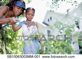 Stock Photography - mother and daughter 
(8-9 years) watering 
garden, low angle 
view. fotosearch 
- search stock 
photos, pictures, 
images, and photo 
clipart