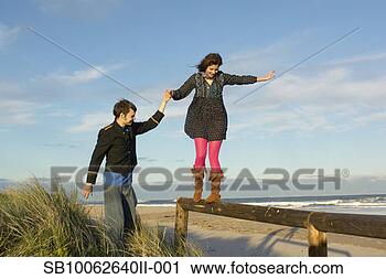 Stock Photography - teenage girl (16-17) 
and young man 
at seashore,  
girl balancing 
on. fotosearch 
- search stock 
photos, pictures, 
images, and photo 
clipart