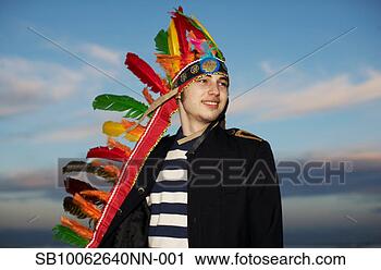 Stock Photography - young man wearing 
feather headdress 
against sky, sunset. 
fotosearch - search 
stock photos, 
pictures, images, 
and photo clipart