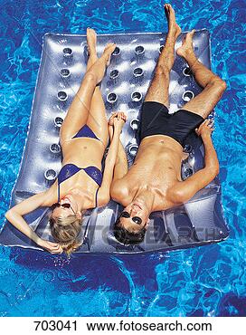 Stock Photography - couple relaxing 
on an inflatable 
in a swimming 
pool. fotosearch 
- search stock 
photos, pictures, 
images, and photo 
clipart
